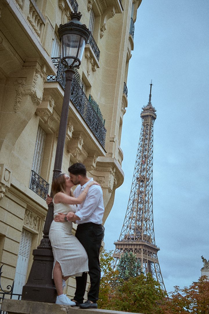 Séance de couple sous un réverbère parisien, tour Eiffel en fond