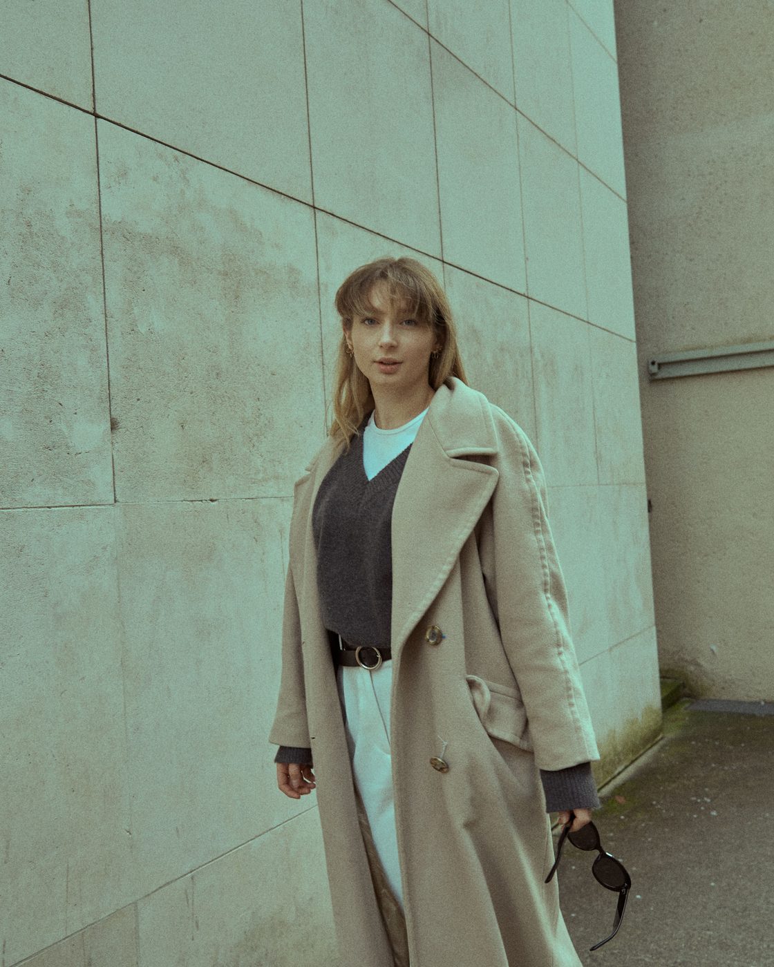 Portrait devant un mur beige, manteau long