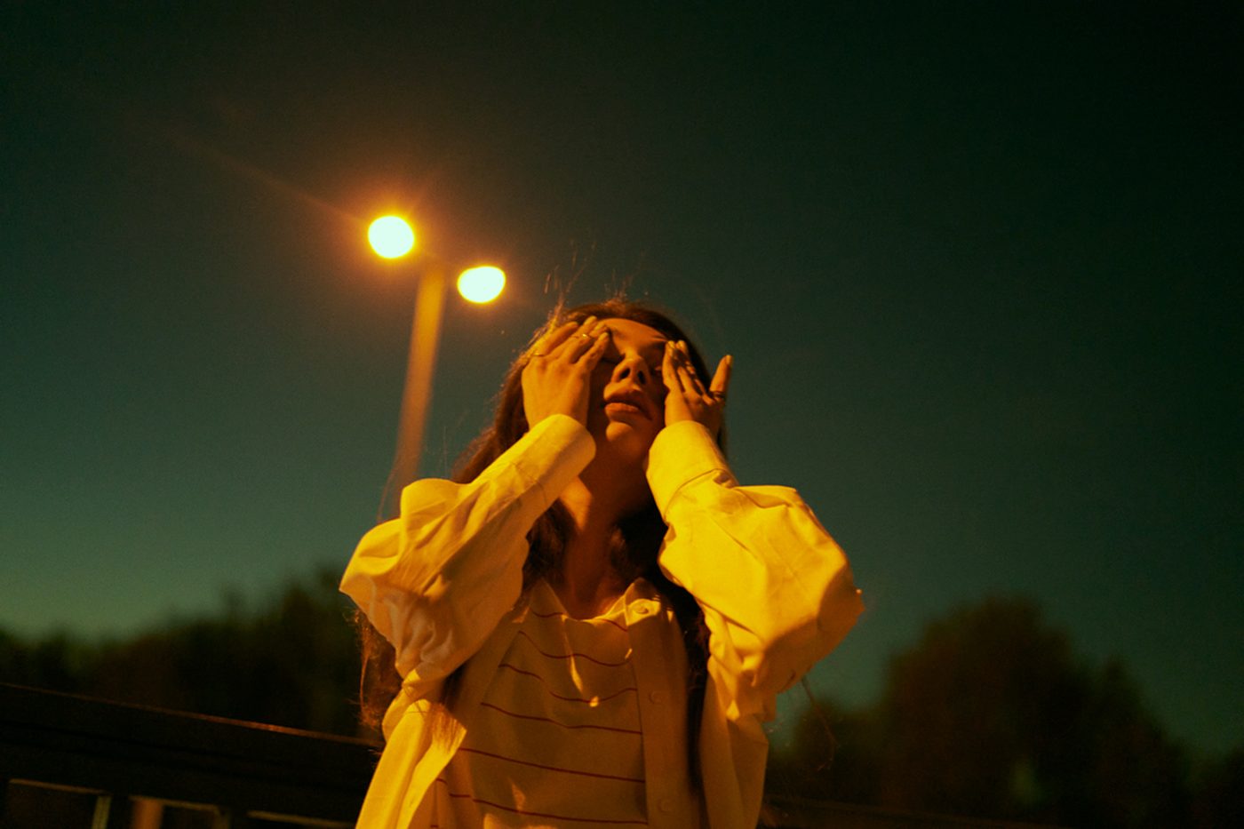 Portrait de nuit, mains sur le visage