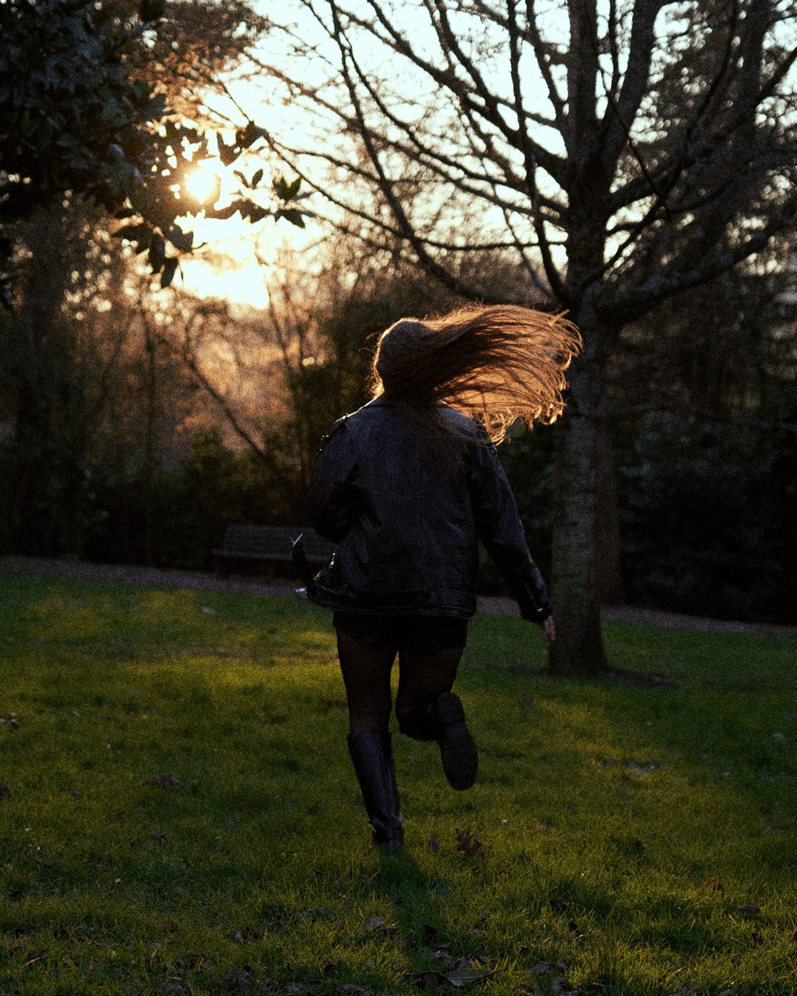 Portrait en mouvement dans un parc, cheveux au vent