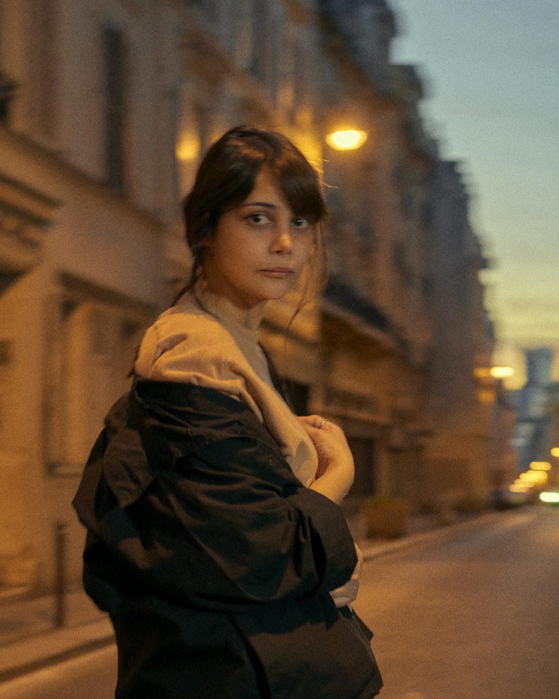 Portrait dans une rue le soir, manteau sombre