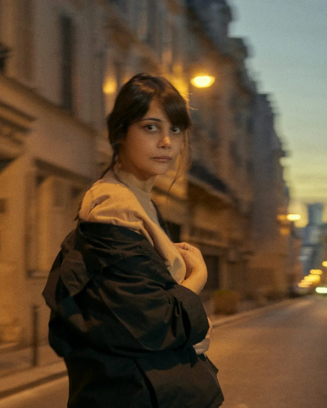 Portrait dans une rue le soir, manteau sombre